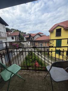 a balcony with two chairs and a yellow building at LevOasi 9 - Lake and mountains escape in Levo