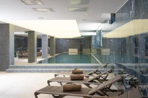a swimming pool with lounge chairs in a building at Visula Hotel & Spa - New Opening 2026 in Medulin