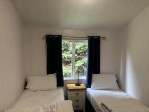 two beds in a small room with a window at Newquay - Deluxe 3 bed Lodge Willows Way 47, Newquay Parkdean, Holiday Park in Newquay +38 photos