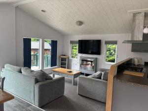 a living room with two couches and a kitchen at Newquay - Deluxe 3 bed Lodge Willows Way 47, Newquay Parkdean, Holiday Park in Newquay