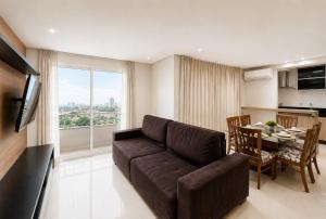 a living room with a couch and a dining room at Luxurious 2-Bedroom Duplex with Gourmet Balcony in Goiânia