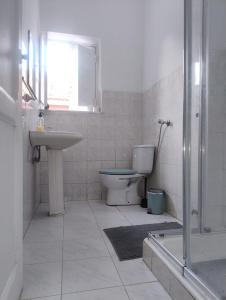 a bathroom with a toilet and a sink and a shower at Come Inn Costa da Caparica in Costa da Caparica
