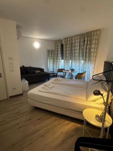 a bedroom with a large bed and a living room at GardaBreak Rooms&Breakfast Holiday Apartments in Riva del Garda