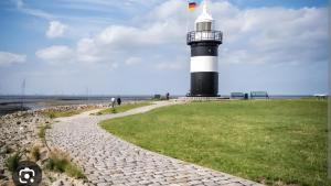 a lighthouse with a flag on top of it at Glücks-Gezeiten in Wurster Nordseeküste
