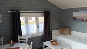 a bedroom with a bed and a table and a window at Glücks-Gezeiten in Wurster Nordseeküste