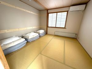 two beds in a room with a window at Kitamachi Home in Higashikawa