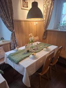 a table with a white table cloth and flowers on it at Gaststätte Liebl in Wiesent +30 photos