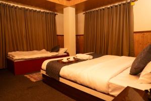 two beds in a hotel room with curtains at The Lume, Lachung in Lachung
