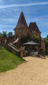 an old brick building with a gazebo in a yard at Chambre de la Tour 1 in Milhac