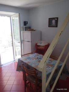 a dining room with a table and a refrigerator at Casa vacanze Torre in Cefalù +9 photos