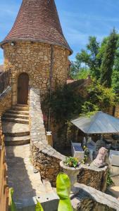 a large stone building with a stairway leading to a door at Chambre de la Tour 1 in Milhac