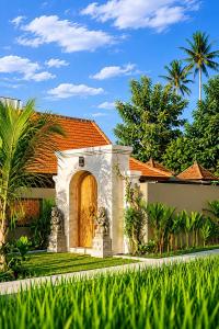 a house with a wooden door in a yard at Ardinia Villa Ubud Private Pool in Ubud