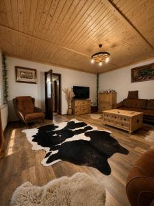 a living room with a cow rug on the floor at Casa Rosso in Valea Măceşului