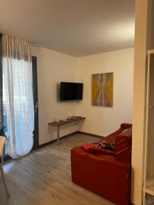 a living room with a bed and a television at GardaBreak Rooms&Breakfast Holiday Apartments in Riva del Garda