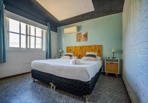 a bedroom with a large bed with a teddy bear on it at PASTORA Suites & Hostel - Punta del este in Punta del Este +52 photos