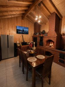 a dining room with a table and a fireplace at Casa Rosso in Valea Măceşului