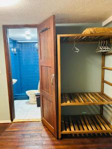 a bathroom with a toilet and a closet with a door at Posada Los Olivos in Baños