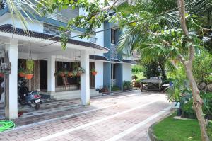 a house with a courtyard in front of it at Elroy Homestay in Kalpetta