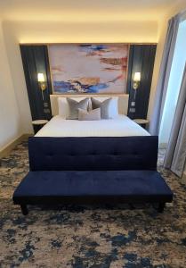a bedroom with a large bed with a blue couch at Trouville Bournemouth - OCEANA COLLECTION in Bournemouth +99 photos