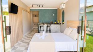 a bedroom with a bed and a kitchen with a bar at BayShore Lofts in Cabo Frio