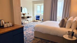 a bedroom with a bed and a desk and a mirror at Trouville Bournemouth - OCEANA COLLECTION in Bournemouth