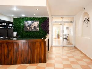 a lobby with a green wall with a bar at Zona Dorada Living in Mazatlán