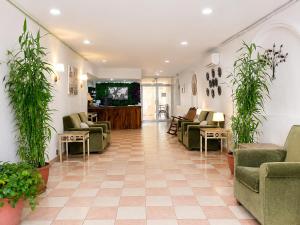 a lobby with couches and chairs and plants at Zona Dorada Living in Mazatlán