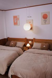 two beds in a room with white walls at Mộng Homestay in Huế in Thôn Trường Giang +31 photos