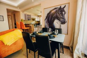 a dining room with a table and a horse picture on the wall at Rouse precious haven in Nakuru +15 photos