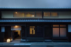 a building with a gate and a building with windows at Ryokan Mugen (Adult Only) in Kyoto