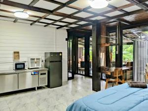 a kitchen and living room with a bed and a table at Lake side villa in Ko Phangan