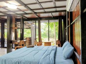 a bedroom with a large bed in a room with windows at Lake side villa in Ko Phangan