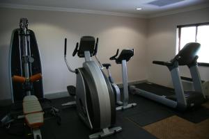 a gym with several cardio machines in a room at Hampshire Hotel - Ballito in Ballito