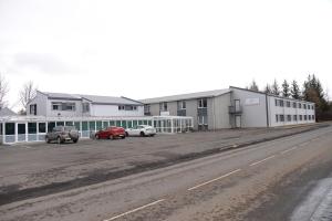 a building with cars parked in a parking lot at Hotel Hvolsvollur - Central South Iceland in Hvolsvöllur