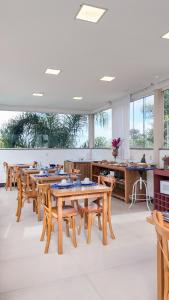 a dining room with wooden tables and wooden chairs at Ilhas Gregas Chalets in Lavras Novas
