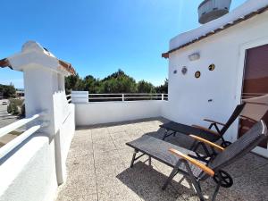 a pair of chairs sitting on the roof of a house at Attico Resplendor Fronte mare in Rosolina Mare +3 photos
