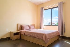 a bedroom with a bed and a large window at DaLaHa City in Da Lat