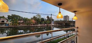 a view of a river from a balcony with lights at Pearl's Lake House in Cochin