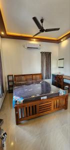 a bed in a room with a ceiling fan at Pearl's Lake House in Cochin