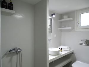 a white bathroom with a sink and a toilet at ÉLYSÉE Boutique in Katavatí