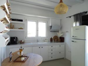 a kitchen with a table and a white refrigerator at ÉLYSÉE Boutique in Katavatí