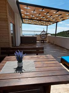 a patio with a wooden table and benches on a deck at Apartments Nahla in Bar