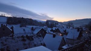 a city with snow covered roofs in the sunset at Ferienwohnung Müller in Bestwig