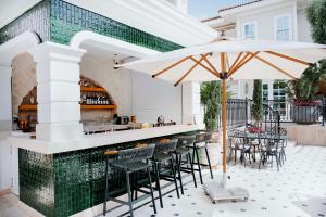 an outdoor bar with chairs and an umbrella at Elegance East Hotel in Antalya +146 photos