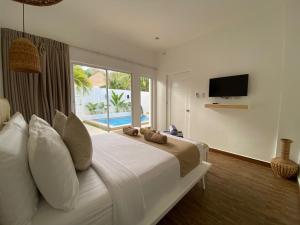 a bedroom with a large bed with a tv on the wall at Pineale Villas, Resort and Spa in Panglao Island