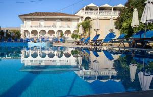 a hotel swimming pool with chairs and umbrellas at Ragias Studios in Tsilivi