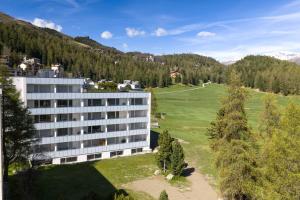 an aerial view of a building with a field and trees at New Exclusive Studio with eFireplace, Pool & Sauna in St. Moritz