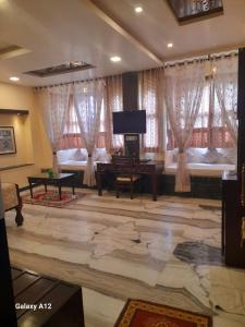 a living room with a grand piano and a television at hotel sargam sadan in Jāmb