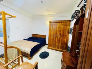 a bedroom with a bed and a wooden cabinet at Devil mountain guest in Kalupahana