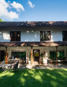 a woman walking in front of a house at Adigars Manor Kandy - A Boutique Heritage Hotel Built in 1804 in Kandy